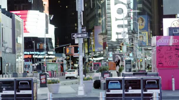 New York, USA - 14 aprile 2020 Una donna escursionista con bagagli e trucco luminoso sul viso si siede a Times Square di notte. Una donna senza maschera protettiva durante la pandemia di coronavirus COVID-19 . — Video Stock