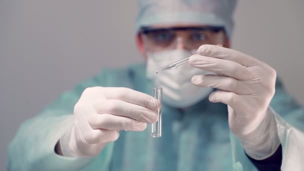 Scientifique dans un laboratoire gros plan dépose une solution médicale dans une éprouvette . — Video