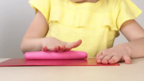 Las manos de los niños cierran rollo de plastilina en el tablero. Los niños juegan con plastilina. Creatividad y creatividad infantil . — Vídeo de stock