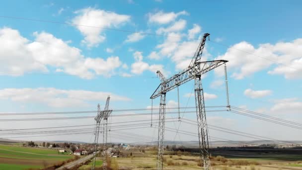 Vista aérea Líneas de transmisión de energía de larga distancia. Postes de alto voltaje que transmiten eficientemente miles de kilovoltios de electricidad entre ciudades — Vídeos de Stock