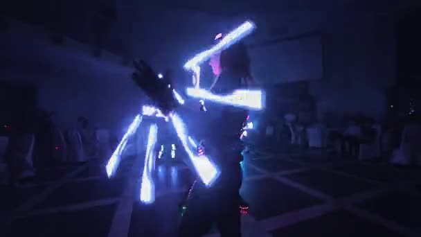 Lazer şovu. Sanatçılar karanlık bir odada dans ve lazer gösterisi yapar. Giysiler buz ve lazer ışığıyla parlıyor. Gece lazer diskosu. — Stok video