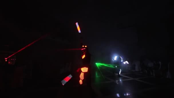 Lasershow. In einem dunklen Raum führen Künstler Tanz und Lasershow vor. Kleidung leuchtet mit Eis und Laserlicht. Nächtliche Laserdisco. — Stockvideo