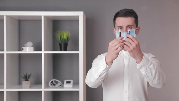 Laboratoriumarts houdt twee reageerbuizen van rode en blauwe kleuren en onderzoekt ze. De arts onderzoekt de laboratoriumreageerbuizen. — Stockvideo