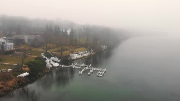 Lotnictwo Latające nad jeziorem w mgle i pochmurnej pogodzie. Nabrzeże jeziora w mglisty dzień. — Wideo stockowe