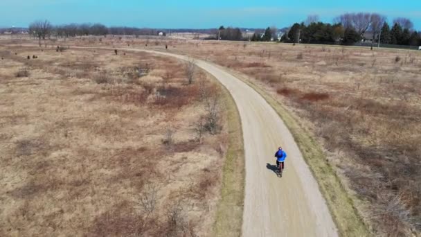 Aerial iew Cyclist ασχολείται με έναν υγιεινό τρόπο ζωής. Βόλτα με ποδήλατο στο πάρκο. Τετρακόπτερο που ακολουθεί τον ποδηλάτη. — Αρχείο Βίντεο
