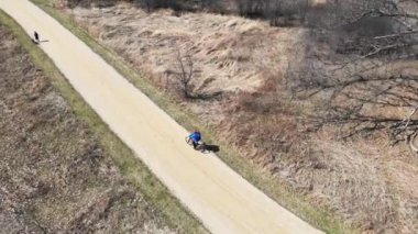 Illinois Eyalet Parkı 'nda bisiklet süren hava manzaralı bir adam. Parkta bisiklete binmek. İHA bisiklet yolunda giden bir bisikletçiyi takip ediyor..