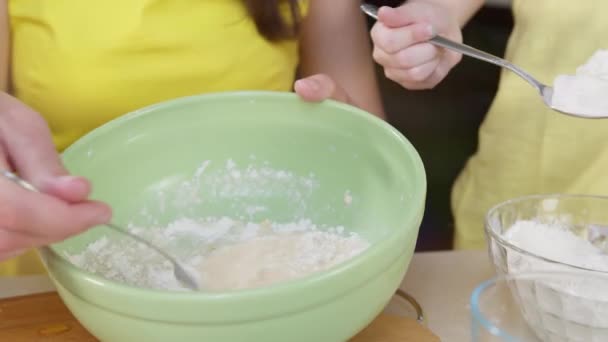 Крупный план приготовления муки для теста. Рука ребенка наливает муку в миску для салата, чтобы сделать муку — стоковое видео