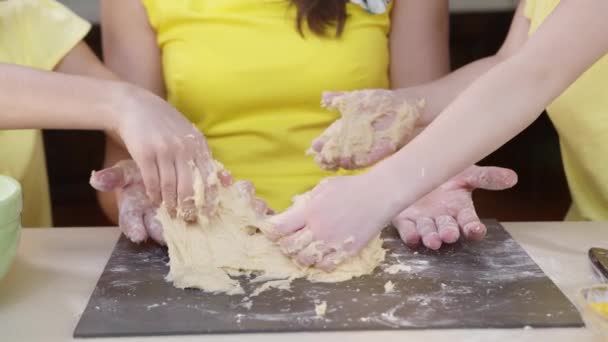 Dětské ruce sevřou těsto na pizzu. Děti pomáhají své matce vařit — Stock video