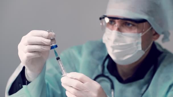 Lekarz zakaźny trzyma w ręku strzykawkę i fiolkę ze szczepionką Covid-19 przeciwko koronawirusowi. Lekarz wstrzykuje szczepionkę do strzykawki. — Wideo stockowe