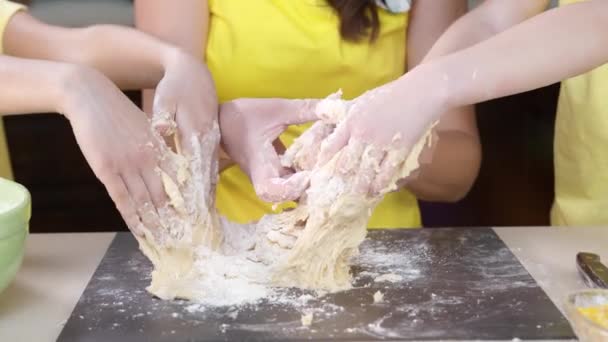 Las manos de los niños cierran amasar masa de pizza. Los niños ayudan a su madre a cocinar — Vídeos de Stock