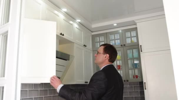 La mano del hombre abre la mesita de noche de la cocina. Mesita de noche de cocina vacía en una cocina brillante blanca . — Vídeos de Stock