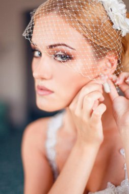 Model gelin küpe takıyor.