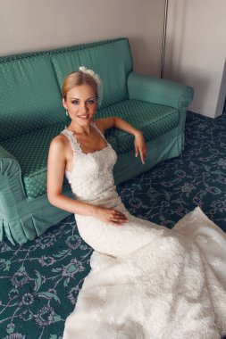 Model gelin kanepede bir otelde poz veriyor.