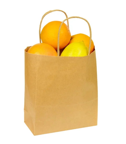 Paper shopping bag full of citrus fruits isolated on white — Stock Photo, Image