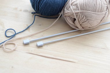 Mavi ve bej ahşap masa üzerinde iplik clews örgü