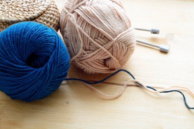 Mavi ve bej ahşap masa üzerinde iplik clews örgü