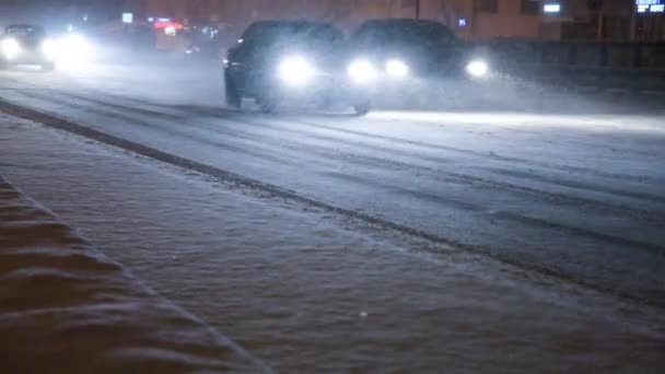 Samochody na drodze w burzy śnieżnej w nocy. — Wideo stockowe
