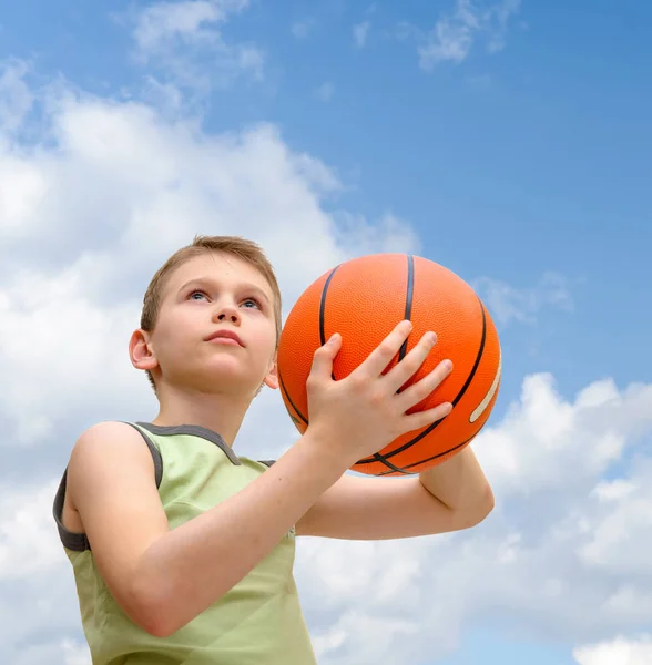 Mały chłopiec z koszykówki na tle błękitnego nieba — Zdjęcie stockowe