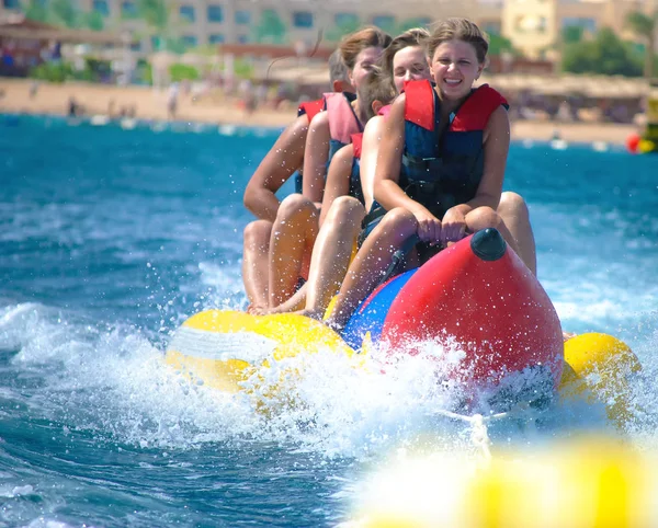 People ride on banana boat