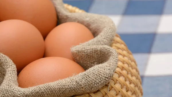Яйця в кошику з домотканою тканиною — стокове фото