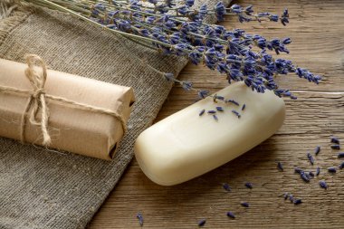 Lavanta sabun ahşap arka plan üzerinde kurutulmuş lavanta çiçekleri ile