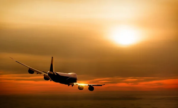 Flygplan på himlen vid solnedgången — Stockfoto