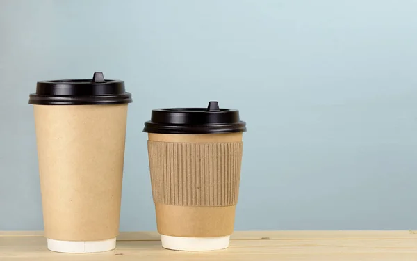 Két papír a csésze kávé a fal mellett az asztalon — Stock Fotó
