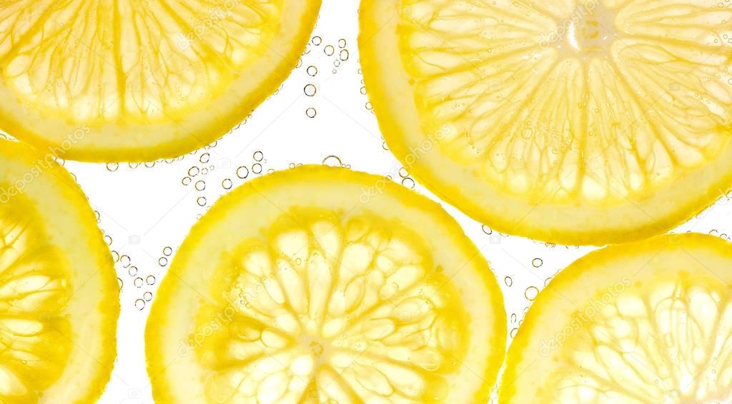 Slices of lemon in water with air bubbles