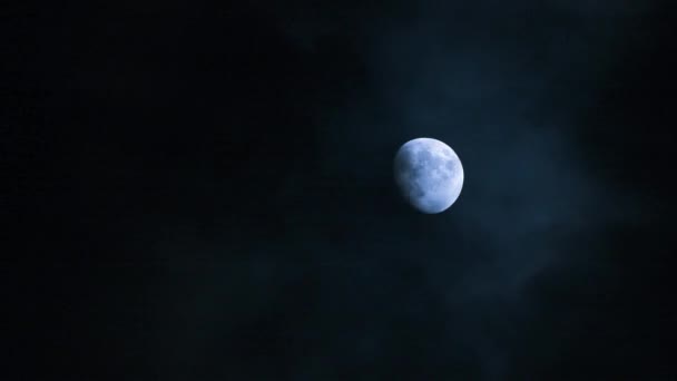 Pleine lune derrière des nuages rapides la nuit 