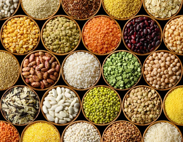 Varias legumbres y cereales de colores sobre fondo negro — Foto de Stock