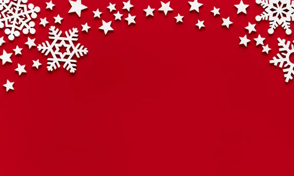 Weihnachten minimale Attrappe von weißen Schneeflocken und Sternen auf rotem Papier Hintergrund. flache Lage, Draufsicht. — Stockfoto