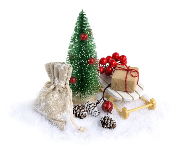 Miniatűr karácsonyfa hóban karácsonyi ajándékokkal a szánon elszigetelt fehér. — Stock Fotó