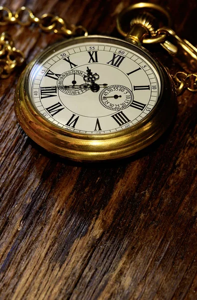 Alte goldene Taschenuhr auf verwittertem Holzhintergrund — Stockfoto