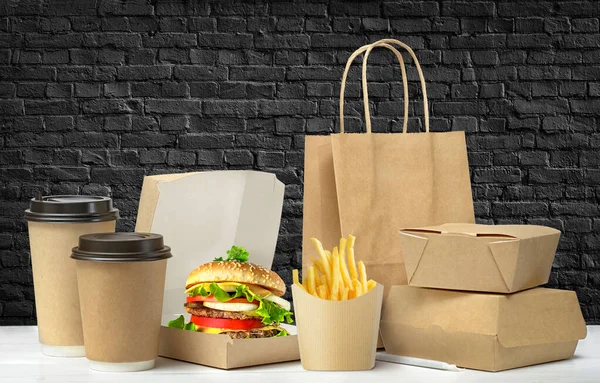Fast food big lunch packaging set on black brick wall background. — Stock Photo, Image