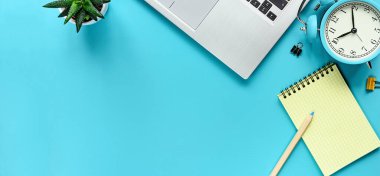 Ofis çalışma masası. Not defteri, dizüstü bilgisayar ve çalar saat. Yukarıdan kopyalama alanı ile görüntüle.