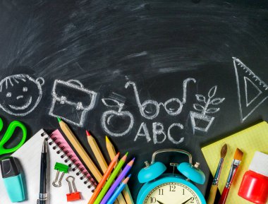 Tahta üzerine okul malzemeleri ve tebeşir çizimleri. Boşluğu kopyala