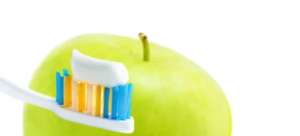 Toothbrush with squeezed paste close-up and green apple isolated on white. Dental care concept. Shallow DOF, selective focus. — Stock Photo, Image