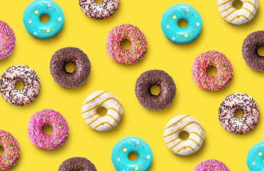 Delicious donuts pattern on a yellow background. Top view. Flat lay. Summer concept