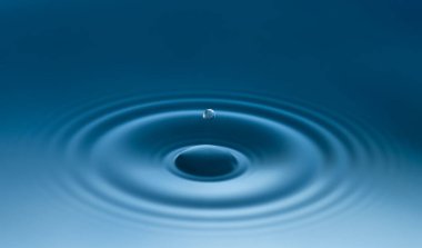 Güzel çember dalgalanmaları ve düşen su damlaları.