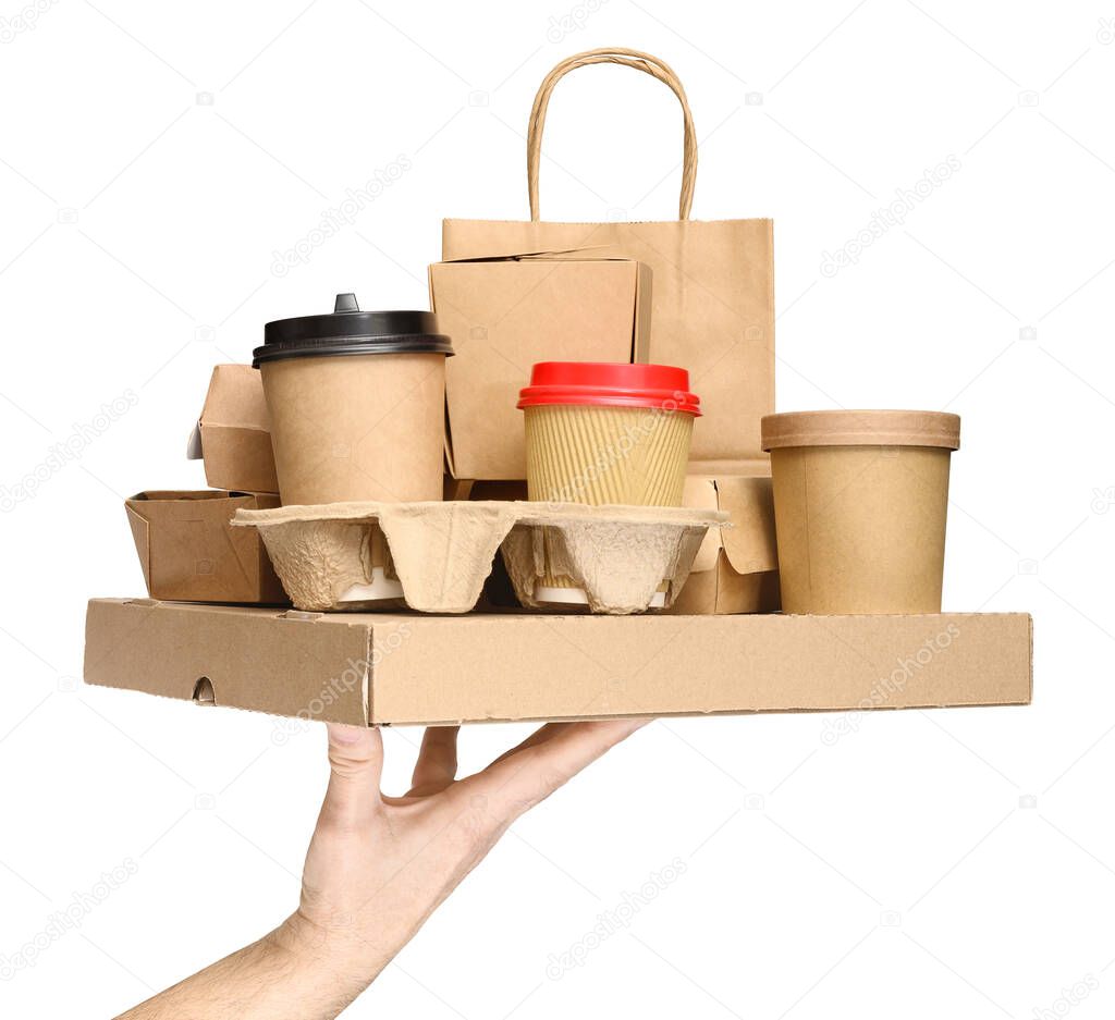 Hand holding various take-out food containers, pizza box, coffee cups in holder and paper bag isolated on white. Food delivery service