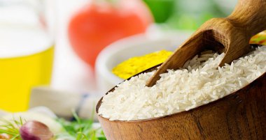 Baharat ve sebzeli ahşap kasede pişirilmemiş uzun pirinç basmatı..