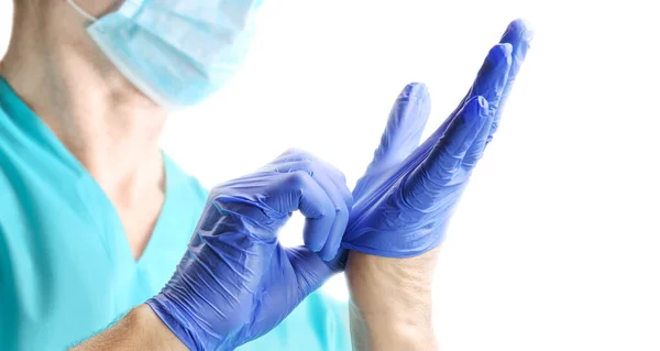 Lekarz Mundurze Medycznym Zakładający Niebieskie Rękawice Lateksowe Izolowane Białym Tle — Zdjęcie stockowe