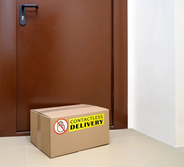 Livrarea fără contact a rămas la uşă în timpul carantinei. Intrare apartament cu cutie livrată. Controlul măsurilor de prevenire epidemică a coronavirusului . — Fotografie, imagine de stoc