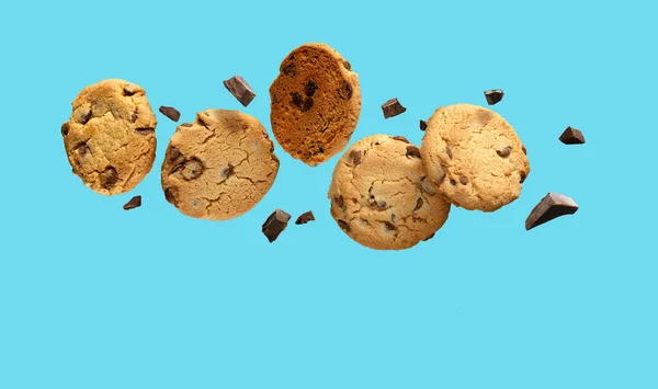 Biscotti al cioccolato che sorvolano lo sfondo blu acqua. Copia spazio — Foto Stock