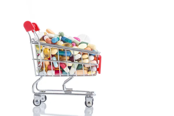 Isolated shopping cart full of medicine with pills and capsules — Stock Photo, Image