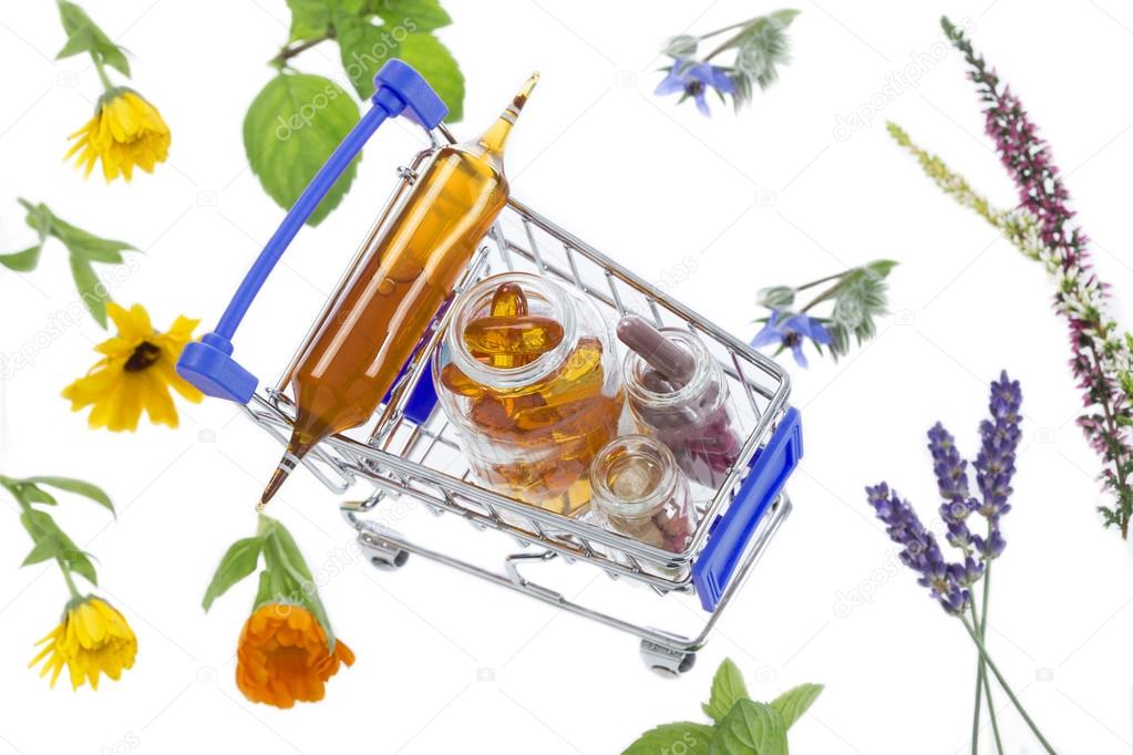 Shopping cart full of pharmaceutical drug and medicine pills over medicinal plants