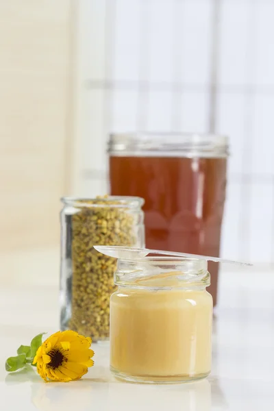 Golden bee pollen in small glass jars with honey and — Stock Photo, Image