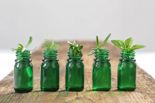 Bouteille verte d'huile essentielle aux herbes fraîches et aux plantes médicinales — Photo