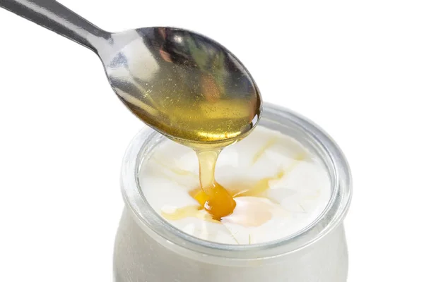 Iogurte e verter mel sobre fundo branco — Fotografia de Stock