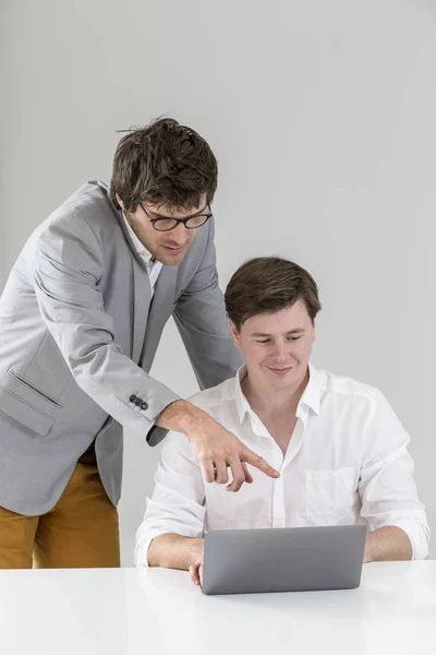 讨论项目在笔记本电脑在会议上的两个商人的肖像 — 图库照片
